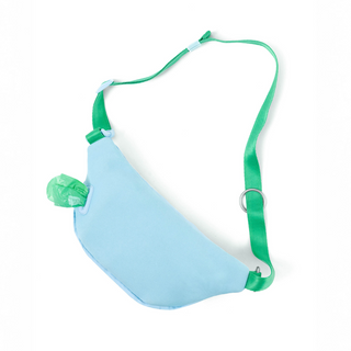 Light blue fanny pack walking bag worn crossbody-style with green strap and attached poop bag dispenser