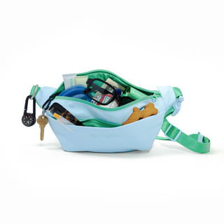 Light blue Springland fanny pack open to show interior with dog treats, water bottle, keys, and supplies